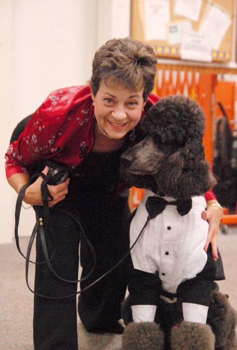 Elice with her poodle in a holiday outfit
