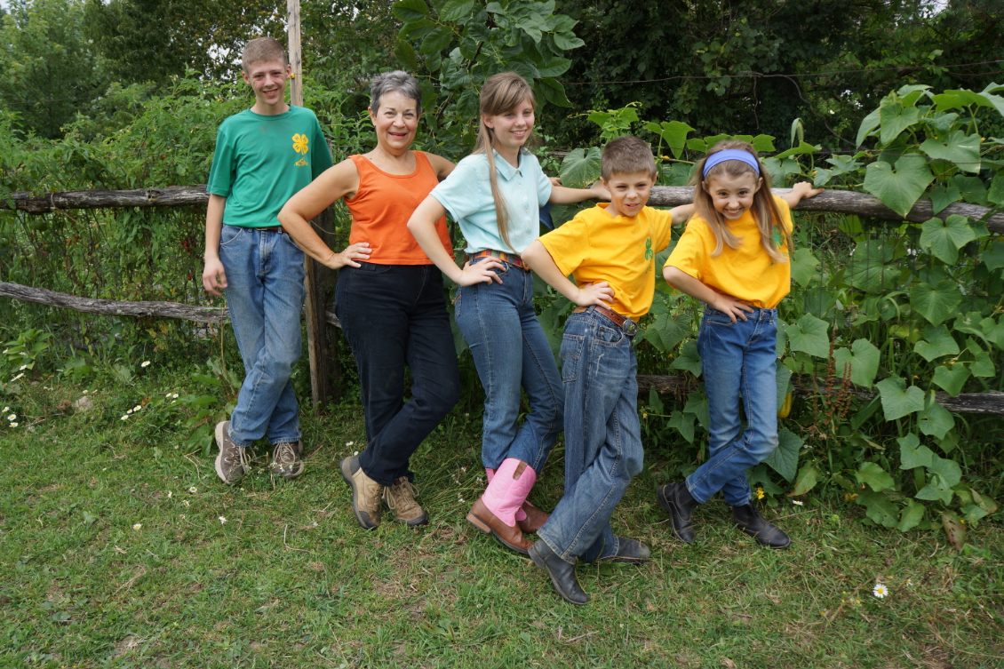 Children gathered by a fence in the garden