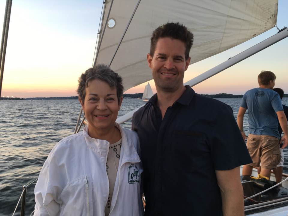 Elice and her son on a sailboat at sunset